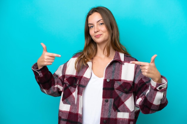 Jovem mulher caucasiana isolada em fundo azul orgulhosa e satisfeita