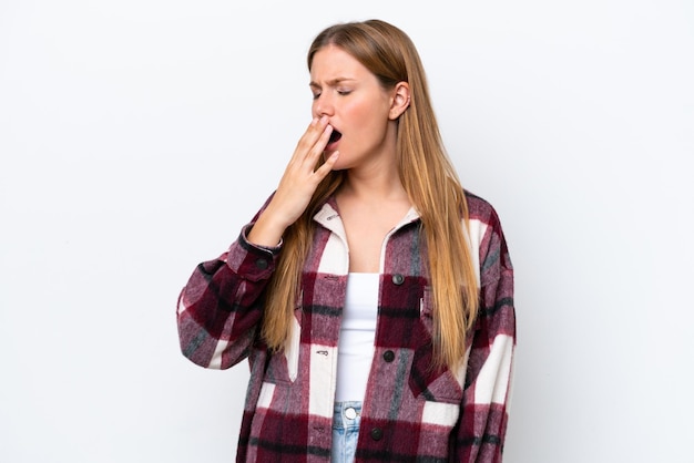 Jovem mulher caucasiana isolada em fundo branco bocejando e cobrindo a boca aberta com a mão