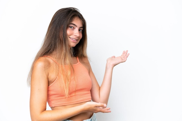 Jovem mulher caucasiana isolada em fundo branco estendendo as mãos para o lado para convidar a vir