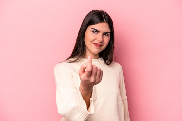 Jovem mulher caucasiana isolada em fundo rosa apontando com o dedo para você como se estivesse convidando para se aproximar