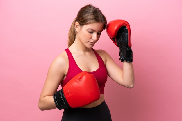 Jovem mulher caucasiana isolada em fundo rosa com luvas de boxe