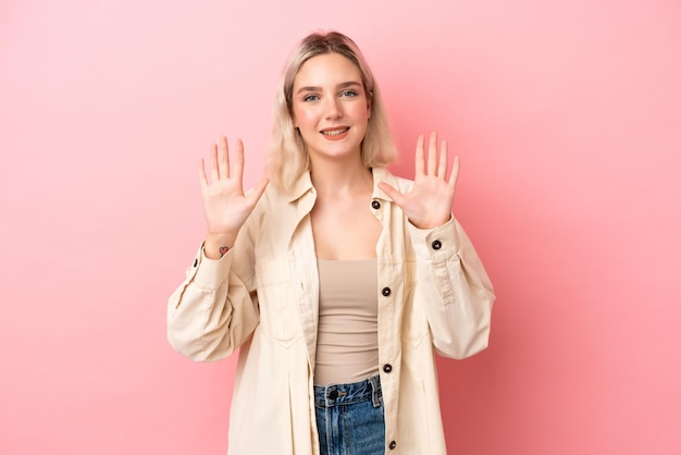 Jovem mulher caucasiana isolada em fundo rosa contando dez com os dedos