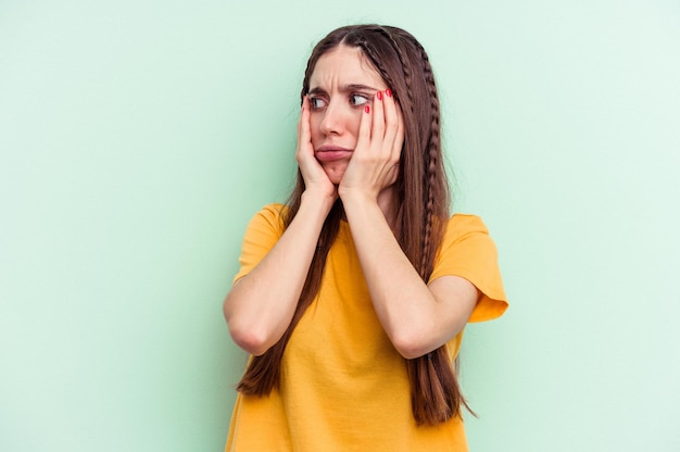 Jovem mulher caucasiana isolada em fundo verde com medo e medo.