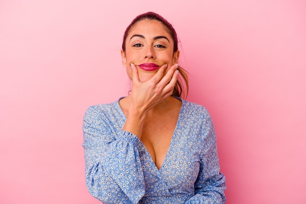 Jovem mulher caucasiana isolada em rosa, tendo uma ideia, o conceito de inspiração.