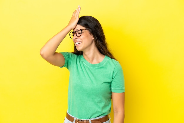 Jovem mulher caucasiana isolada em um fundo amarelo percebeu algo e pretende a solução