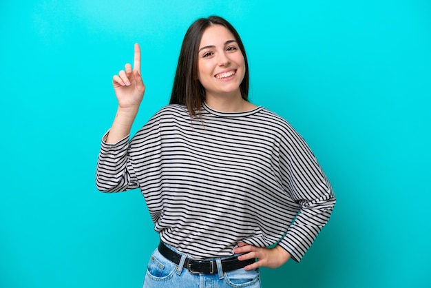 Foto jovem mulher caucasiana isolada em um fundo azul apontando para uma ótima ideia