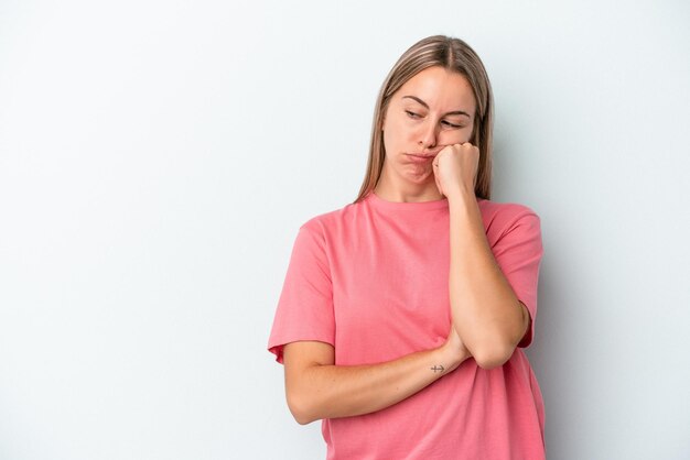 Jovem mulher caucasiana isolada em um fundo azul que se sente triste e pensativa, olhando para o espaço da cópia.