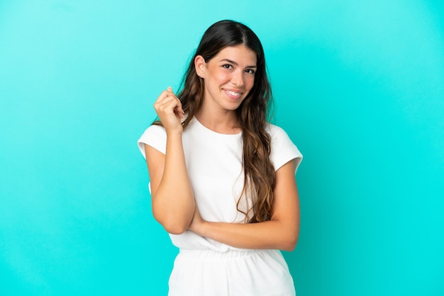 Jovem mulher caucasiana isolada em um fundo azul rindo