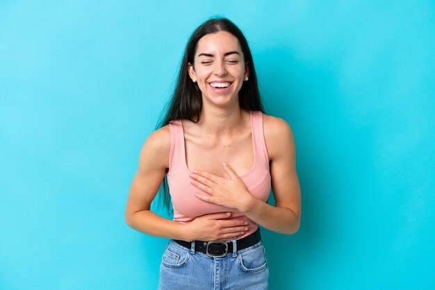 Jovem mulher caucasiana isolada em um fundo azul sorrindo muito