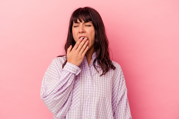 Jovem mulher caucasiana isolada em um fundo rosa bocejando, mostrando um gesto cansado, cobrindo a boca com a mão.