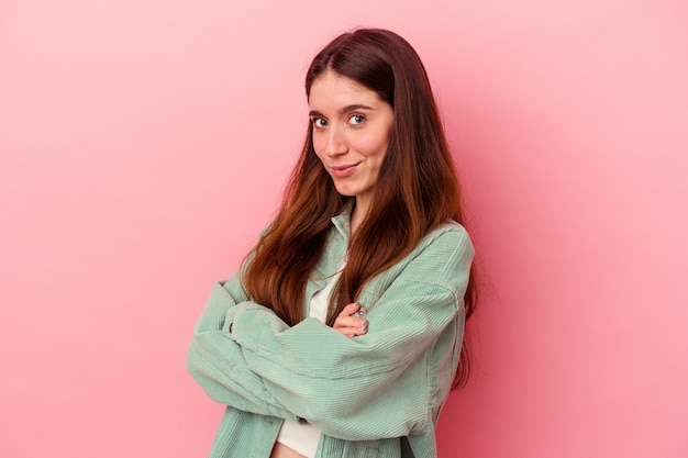 Jovem mulher caucasiana isolada em um fundo rosa cara carrancuda em desgosto, mantém os braços cruzados.