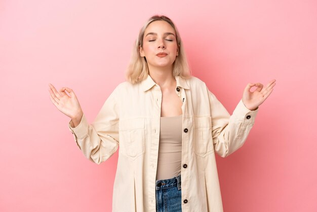 Jovem mulher caucasiana isolada em um fundo rosa em pose zen