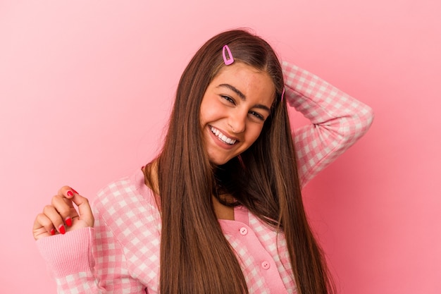 Jovem mulher caucasiana isolada em um fundo rosa, esticando os braços, posição relaxada.