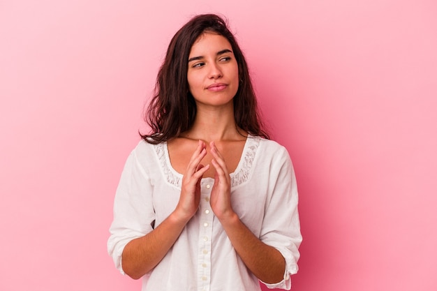 Jovem mulher caucasiana isolada em um fundo rosa, inventando o plano em mente, estabelecendo uma ideia.