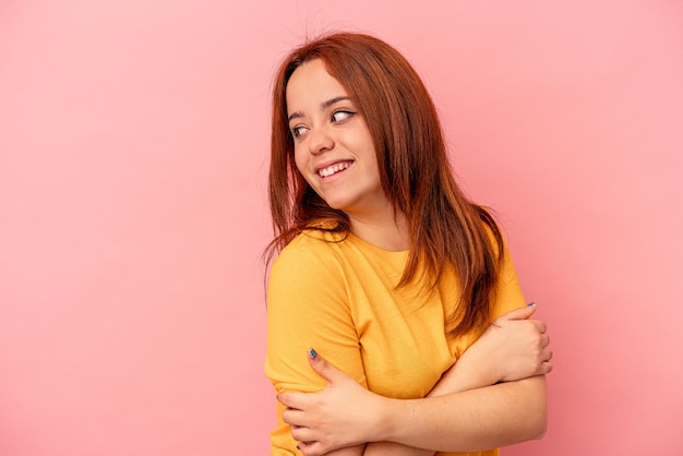 Jovem mulher caucasiana isolada em um fundo rosa, rindo e se divertindo.