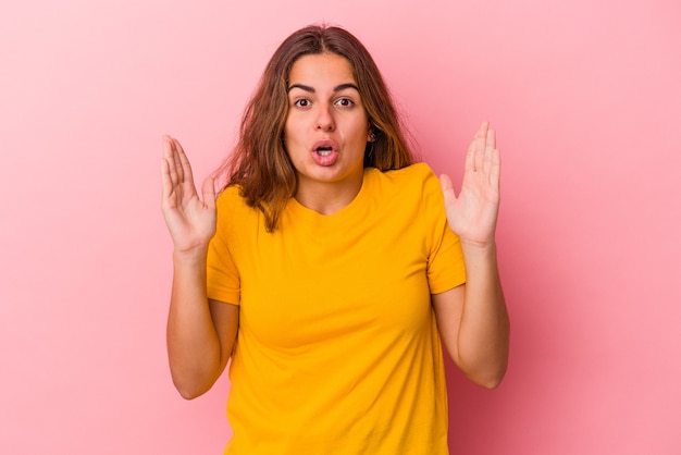 Jovem mulher caucasiana isolada em um fundo rosa, tendo uma ideia, o conceito de inspiração.