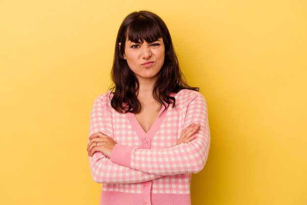 Jovem mulher caucasiana isolada na parede amarela infeliz olhando na câmera com expressão sarcástica.