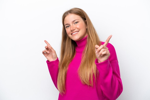 Jovem mulher caucasiana isolada no fundo branco apontando o dedo para as laterais e feliz