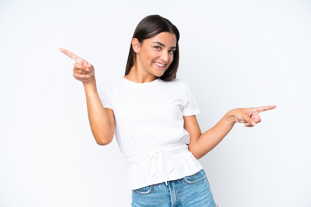 Jovem mulher caucasiana isolada no fundo branco apontando o dedo para as laterais e feliz