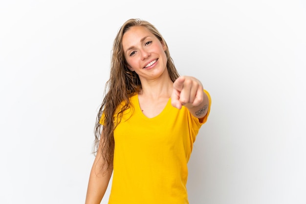 Jovem mulher caucasiana isolada no fundo branco, apontando para a frente com expressão feliz