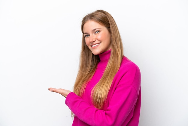 Jovem mulher caucasiana isolada no fundo branco apresentando uma ideia enquanto olha sorrindo para