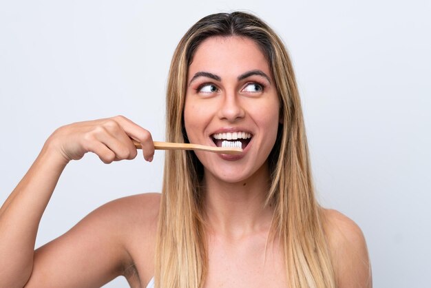 Foto jovem mulher caucasiana isolada no fundo branco com uma escova de dentes