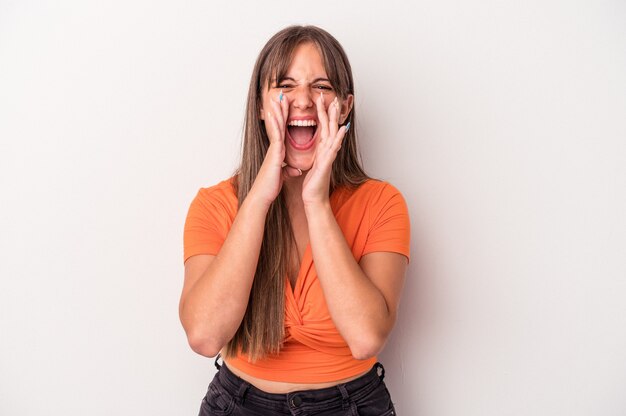 Jovem mulher caucasiana isolada no fundo branco gritando animado para a frente.