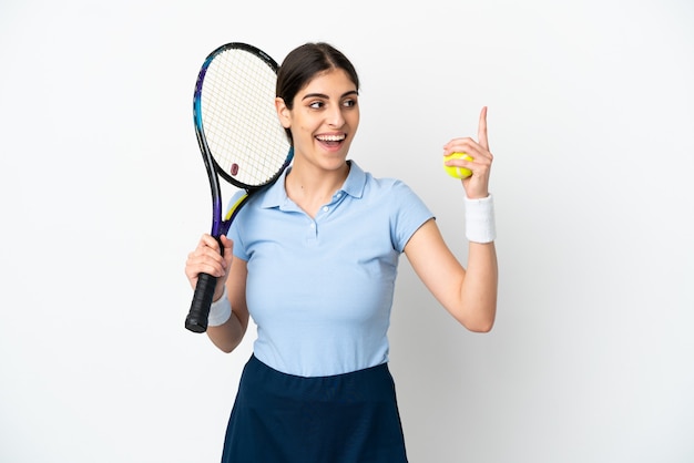 Jovem mulher caucasiana isolada no fundo branco jogando tênis e apontando para cima