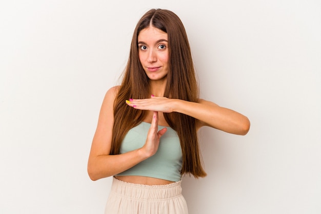 Jovem mulher caucasiana isolada no fundo branco, mostrando um gesto de tempo limite.