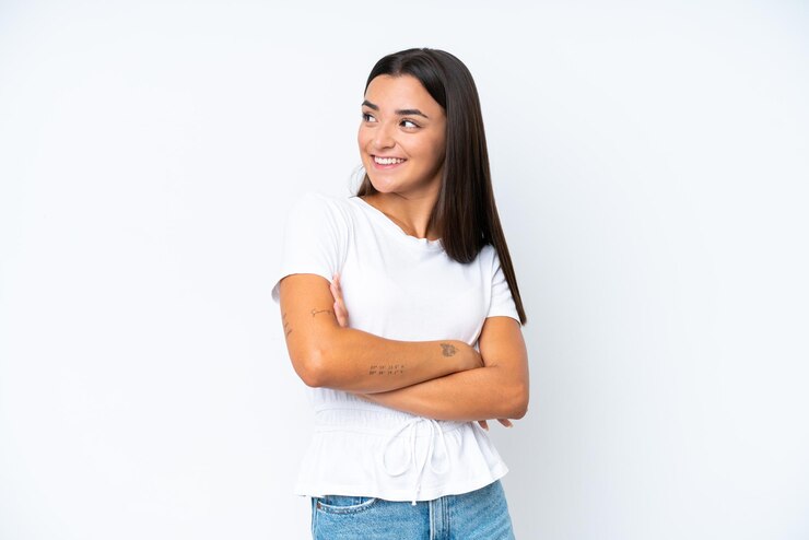 Foto jovem mulher caucasiana isolada no fundo branco, olhando para cima enquanto sorri