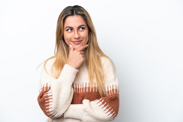 Jovem mulher caucasiana, isolada no fundo branco, olhando para o lado e sorrindo