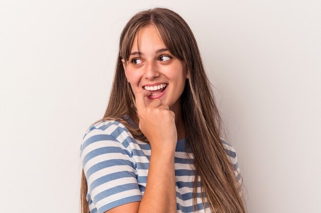 Jovem mulher caucasiana isolada no fundo branco relaxado pensando em algo olhando para um espaço de cópia.