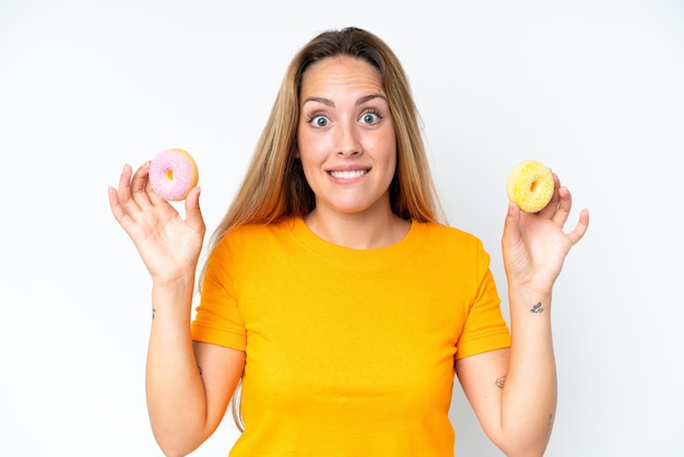 Jovem mulher caucasiana isolada no fundo branco segurando rosquinhas