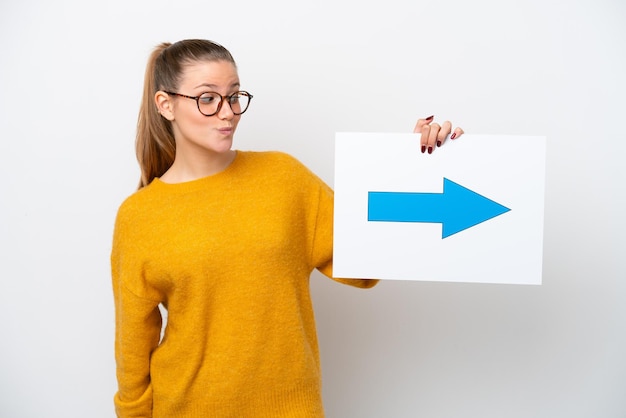 Jovem mulher caucasiana isolada no fundo branco segurando um cartaz com o símbolo de seta