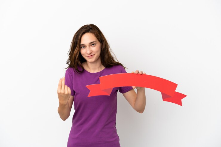 Foto jovem mulher caucasiana isolada no fundo branco segurando um cartaz vazio e fazendo o gesto de aproximar-se