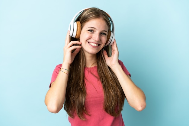 Jovem mulher caucasiana isolada ouvindo música azul