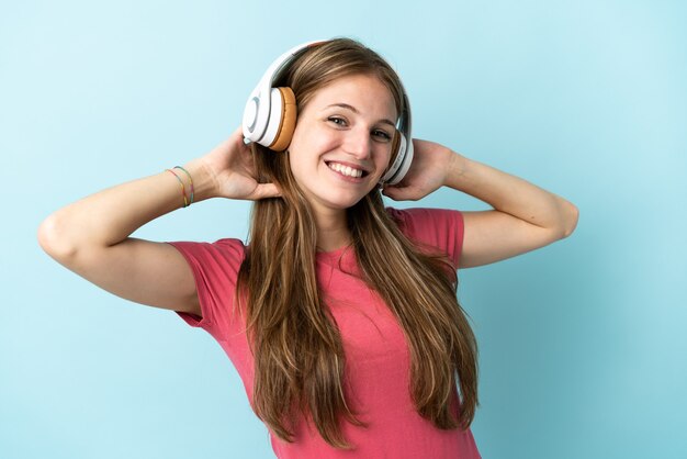 Jovem mulher caucasiana isolada ouvindo música azul