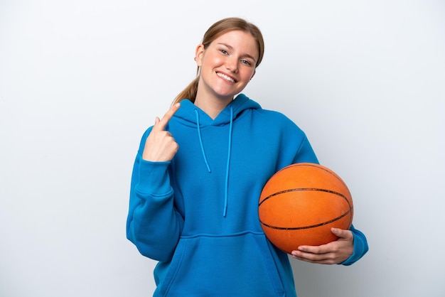 Jovem mulher caucasiana jogando basquete isolada no fundo branco, dando um polegar para cima gesto