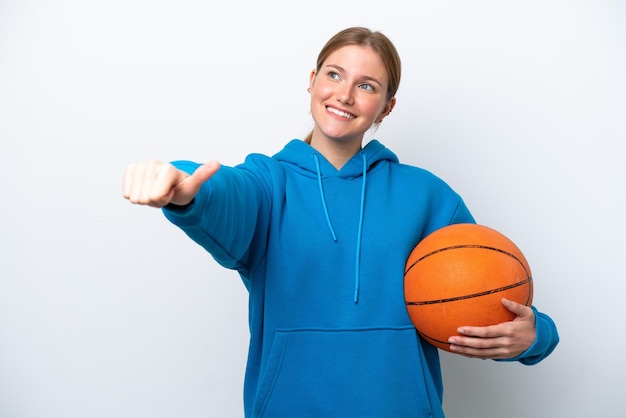 Jovem mulher caucasiana jogando basquete isolada no fundo branco, dando um polegar para cima gesto