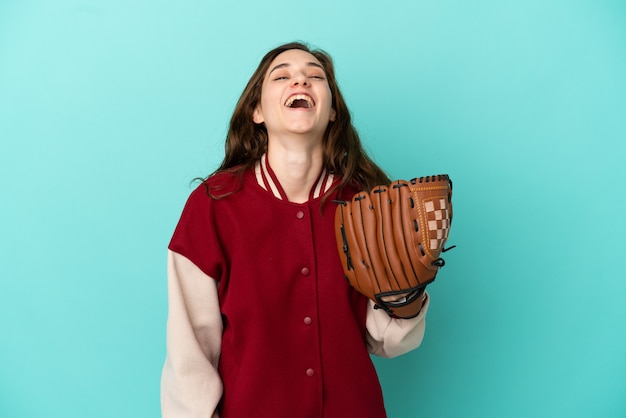 Jovem mulher caucasiana jogando beisebol isolada em um fundo azul rindo