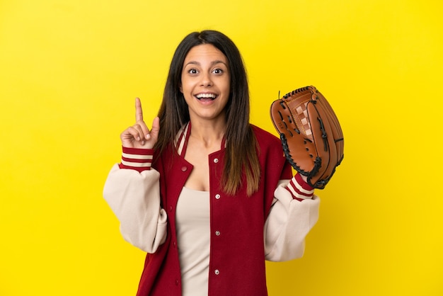 Jovem mulher caucasiana jogando beisebol isolado em um fundo amarelo com a intenção de perceber a solução enquanto levanta um dedo