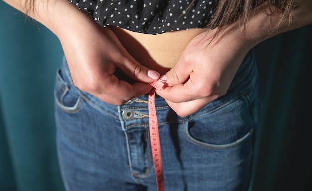 Jovem mulher caucasiana medindo seu corpo