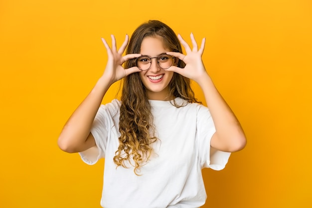 Jovem mulher caucasiana mostrando sinal de ok sobre os olhos