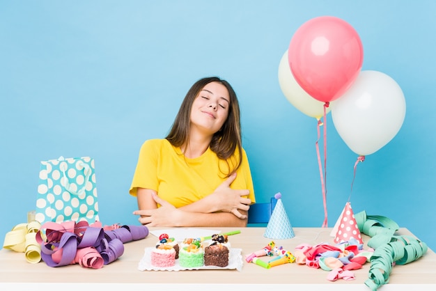 Jovem mulher caucasiana, organizando um abraços de aniversário, sorrindo despreocupada e feliz