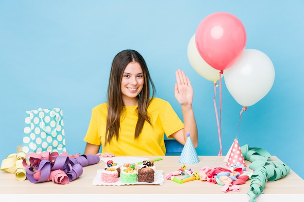 Jovem mulher caucasiana, organizando um aniversário sorrindo alegre mostrando número cinco com os dedos.