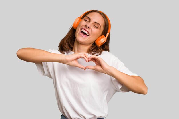 Foto jovem mulher caucasiana ouvindo música com fones de ouvido isolados