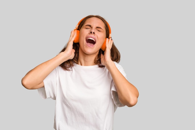 Jovem mulher caucasiana ouvindo música com fones de ouvido isolados