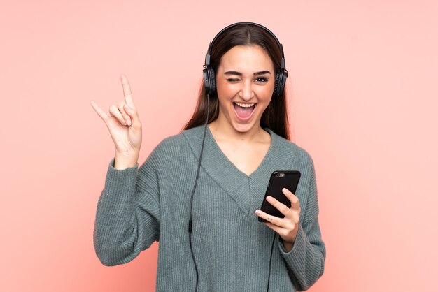 Jovem mulher caucasiana ouvindo música com um celular