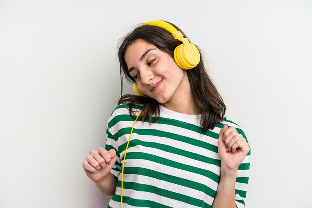 Jovem mulher caucasiana ouvindo música isolada no fundo branco