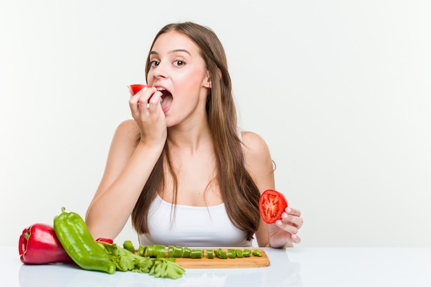 Jovem mulher caucasiana, posando com um tomate